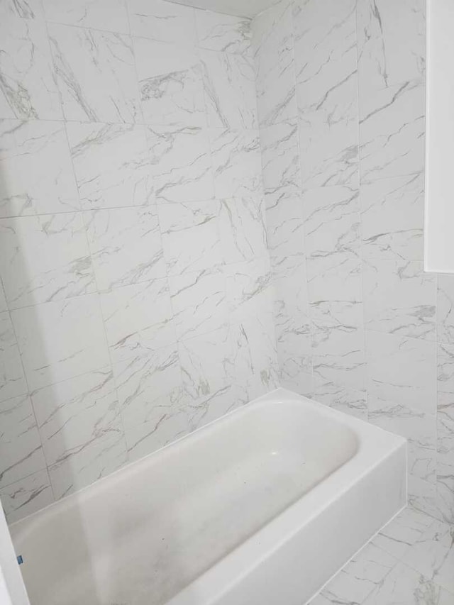 bathroom featuring a bathtub and marble finish floor