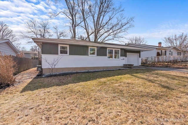 ranch-style home with a garage, aphalt driveway, a front yard, and fence