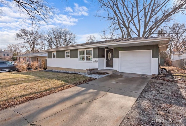 ranch-style home featuring a garage, driveway, and a front yard