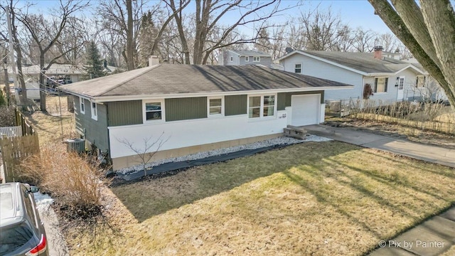 view of front of property with an attached garage, central AC, concrete driveway, a chimney, and a front yard