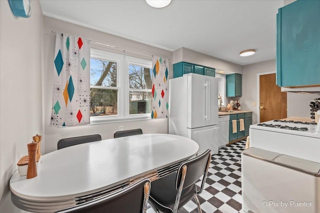 kitchen featuring blue cabinets, white appliances, light countertops, and tile patterned floors