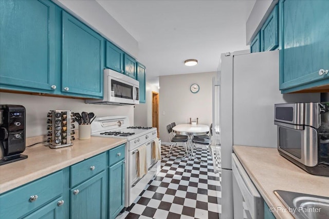 kitchen featuring dark floors, white appliances, blue cabinetry, and light countertops