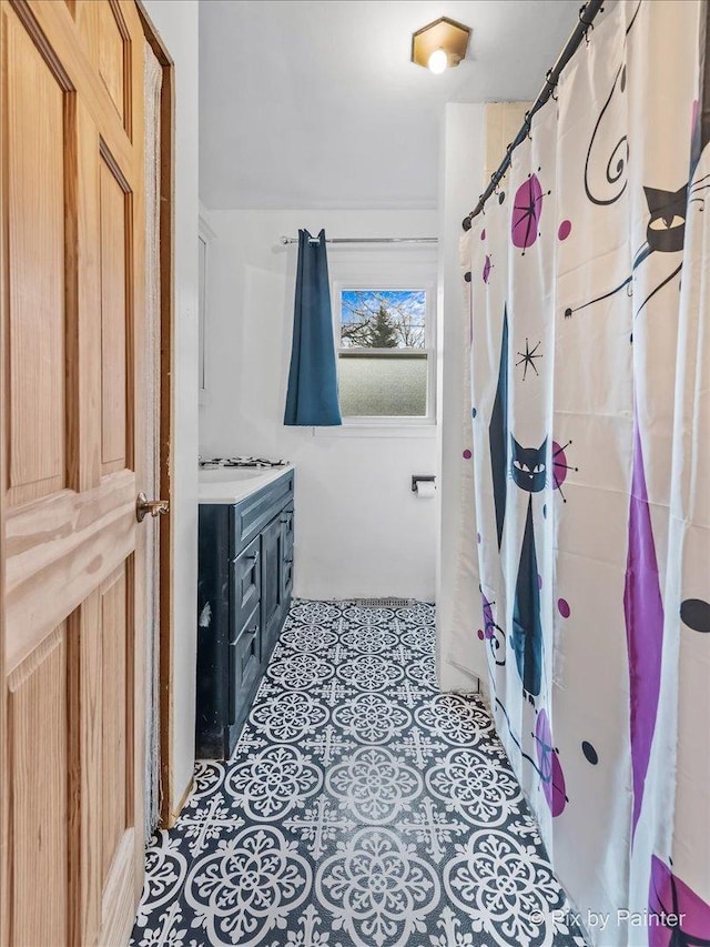 bathroom with a shower with curtain, vanity, and tile patterned floors