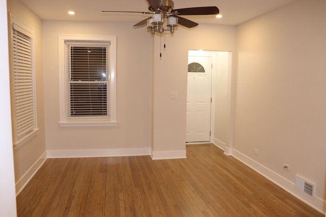 spare room featuring wood finished floors, visible vents, and baseboards