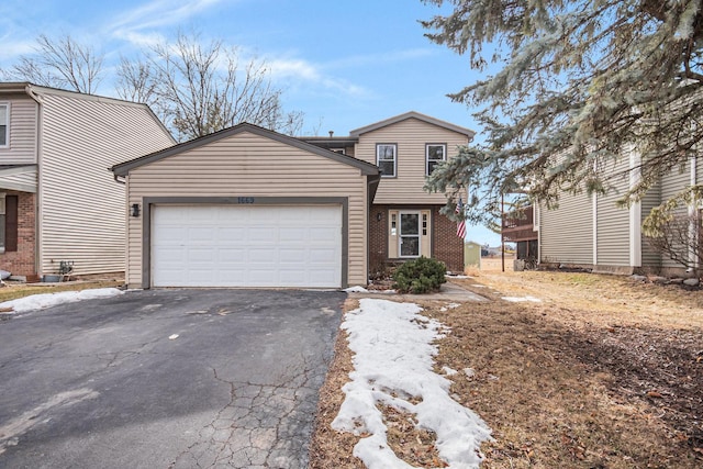 view of front of property with an attached garage, aphalt driveway, and brick siding