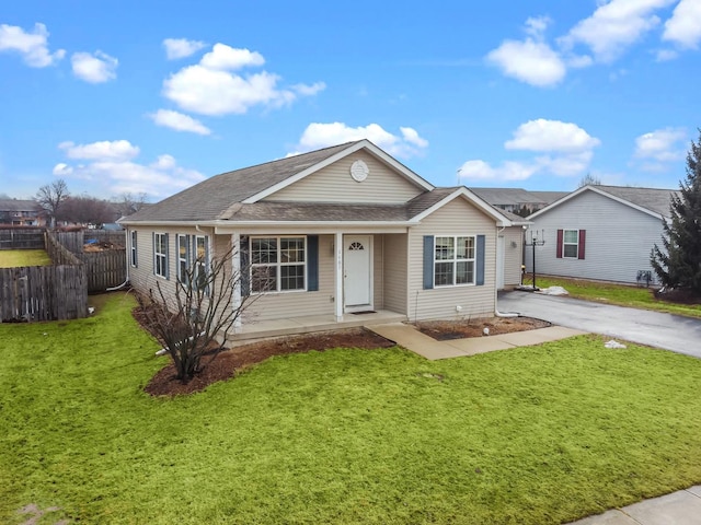 ranch-style house with a front lawn, fence, and aphalt driveway