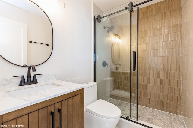 full bath with a stall shower, vanity, and toilet