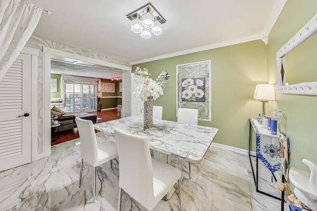 dining room with baseboards, marble finish floor, and crown molding