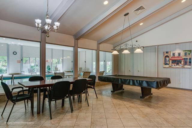 rec room featuring a healthy amount of sunlight, visible vents, vaulted ceiling with beams, and light tile patterned floors