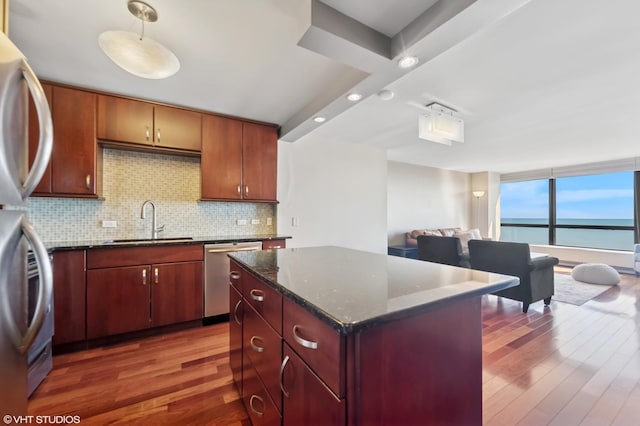 kitchen featuring tasteful backsplash, appliances with stainless steel finishes, dark wood-type flooring, and a sink