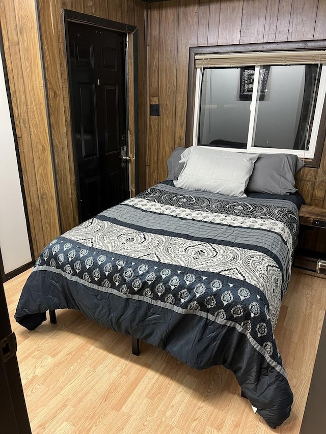 bedroom with wooden walls and wood finished floors