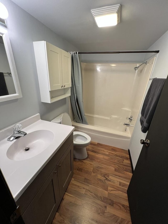 full bathroom featuring wood finished floors, vanity, toilet, and shower / bath combo with shower curtain