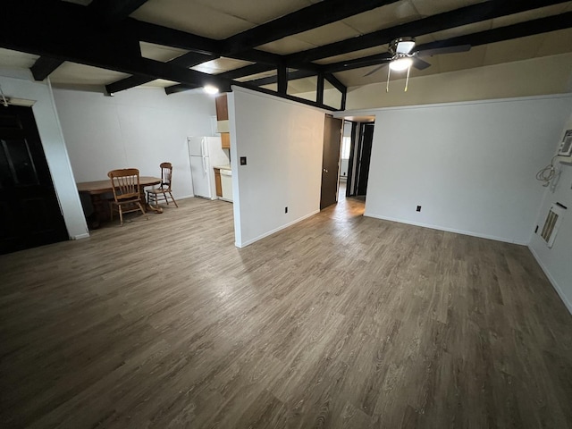 unfurnished living room featuring lofted ceiling with beams, ceiling fan, baseboards, and wood finished floors