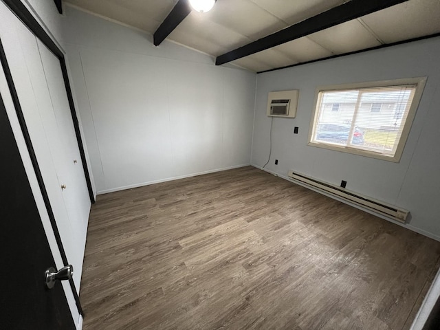 spare room featuring vaulted ceiling with beams, baseboard heating, wood finished floors, and an AC wall unit