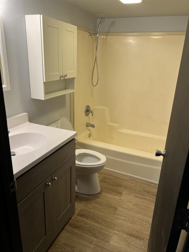 bathroom with shower / bathtub combination, vanity, wood finished floors, and toilet