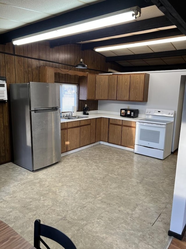 kitchen with white range with electric stovetop, light floors, light countertops, freestanding refrigerator, and a sink