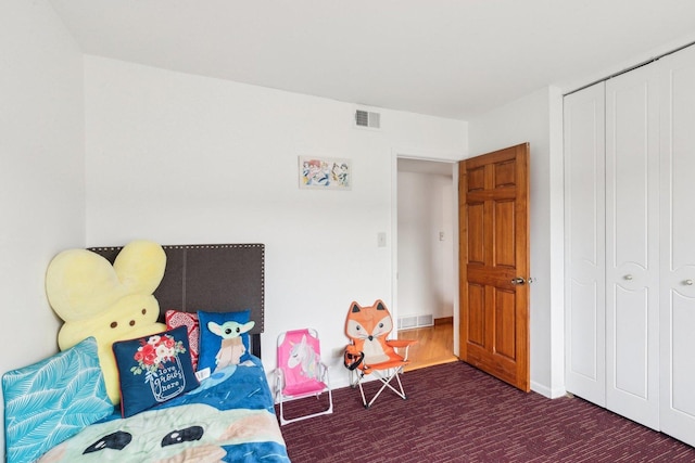 bedroom featuring a closet, carpet flooring, visible vents, and baseboards