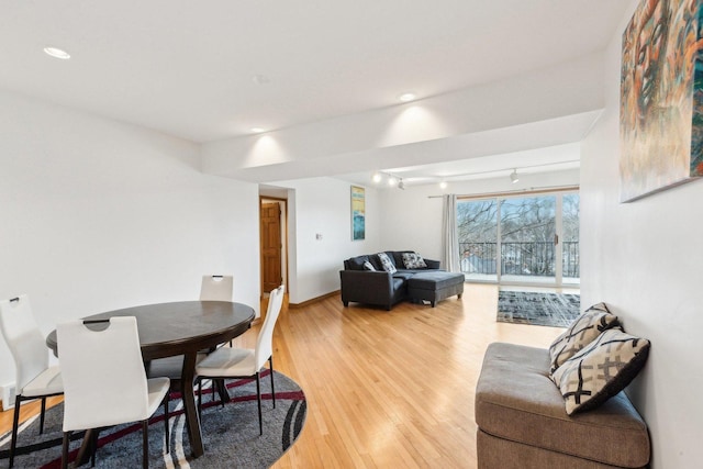 dining room featuring light wood-style flooring, baseboards, track lighting, and recessed lighting