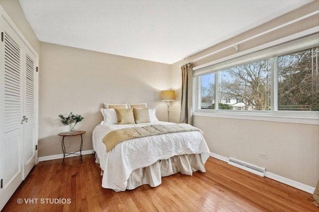 bedroom featuring a closet, wood finished floors, visible vents, and baseboards