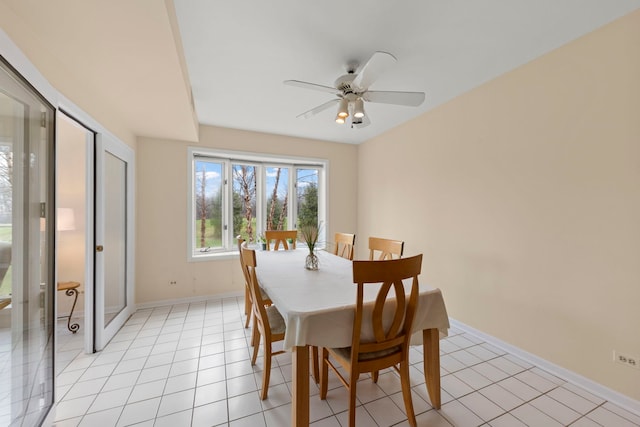 dining space featuring baseboards, a ceiling fan, and light tile patterned floors