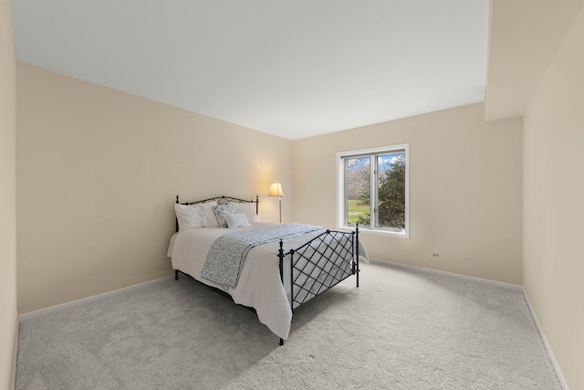 bedroom featuring light colored carpet and baseboards
