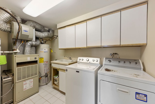 laundry room with water heater, washing machine and dryer, cabinet space, light tile patterned floors, and heating unit