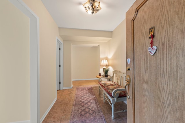 hall with light tile patterned flooring and baseboards