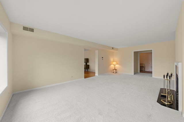 unfurnished living room featuring carpet floors and baseboards