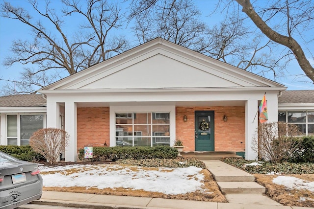 view of front of house featuring covered porch and brick siding