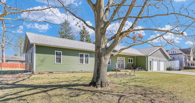 ranch-style home featuring a garage, driveway, a front yard, and fence