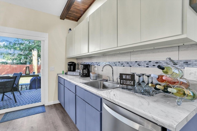 kitchen featuring a sink, tasteful backsplash, dark wood-style floors, light countertops, and dishwasher