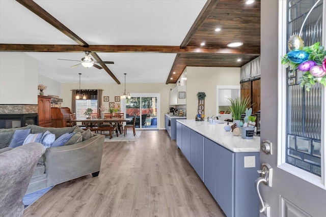living area with beamed ceiling, recessed lighting, light wood-style flooring, washer / dryer, and a ceiling fan