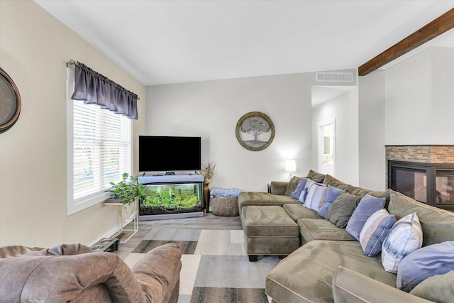 living room featuring visible vents, a multi sided fireplace, and beamed ceiling