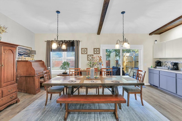 dining space featuring an inviting chandelier, beam ceiling, and light wood-style floors