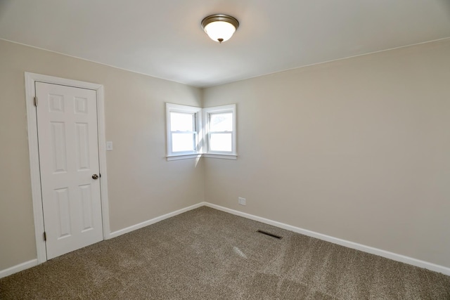 carpeted empty room featuring visible vents and baseboards