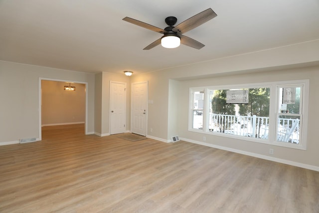 interior space with light wood-style floors, visible vents, baseboards, and a ceiling fan