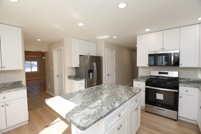 kitchen featuring appliances with stainless steel finishes, a kitchen island, and white cabinetry