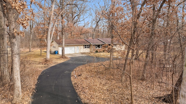 view of front of house featuring an attached garage and aphalt driveway