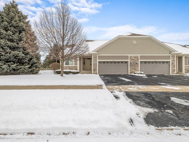 view of front facade featuring a garage, stone siding, and driveway