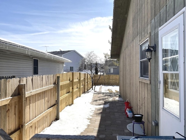 view of snow covered exterior featuring a fenced backyard