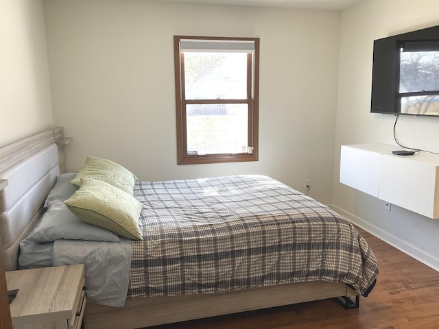 bedroom featuring baseboards and dark wood-type flooring