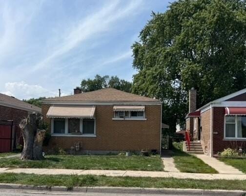 view of home's exterior with a yard, brick siding, and a chimney