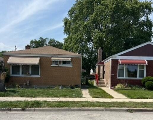 view of home's exterior with brick siding, a lawn, and a chimney