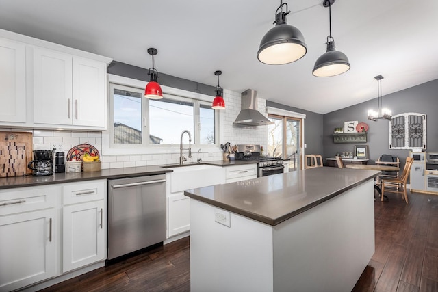kitchen featuring appliances with stainless steel finishes, dark countertops, white cabinets, and a sink