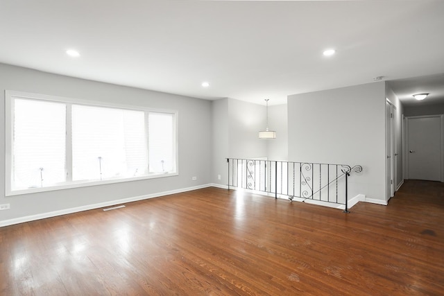 unfurnished room with recessed lighting, wood finished floors, and baseboards