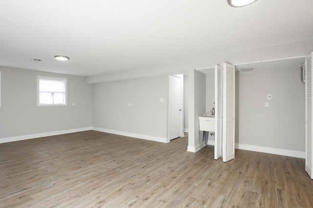 basement with baseboards and wood finished floors