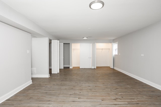 basement featuring baseboards and wood finished floors