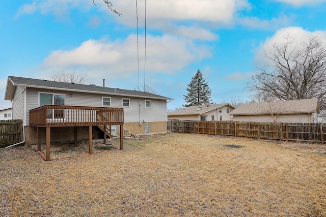 rear view of house featuring a fenced backyard and a deck