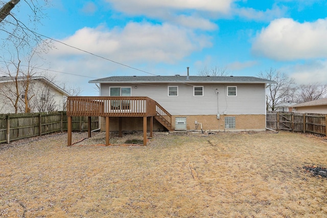 back of property featuring a fenced backyard, brick siding, a deck, and stairs