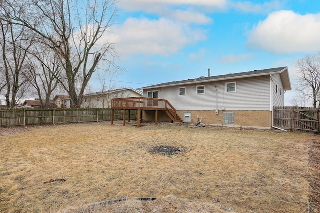 rear view of house featuring a fenced backyard, stairs, a wooden deck, and brick siding